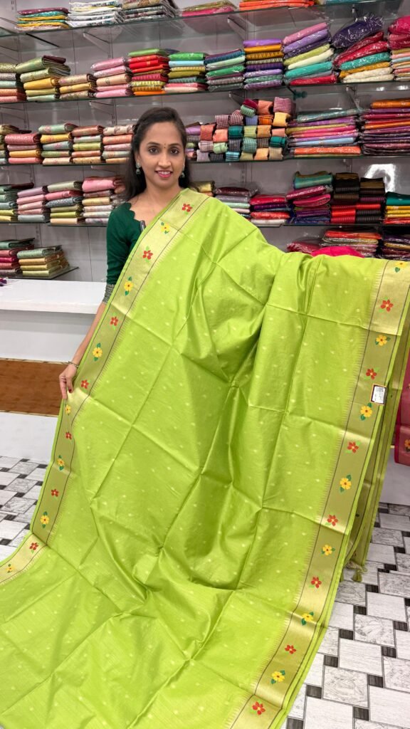 Woman presenting a stunning green Jute Silk Saree with elegant golden details at GM Collections boutique in Bangalore.